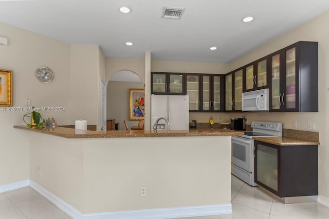 kitchen featuring light tile patterned flooring, sink, light stone countertops, and white appliances