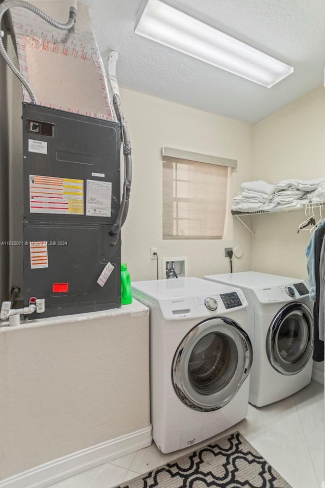 laundry area featuring independent washer and dryer and light tile patterned floors