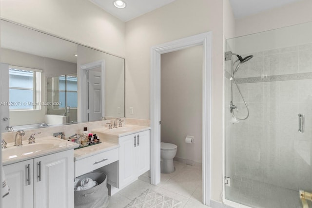 bathroom featuring double vanity, walk in shower, toilet, and tile patterned floors