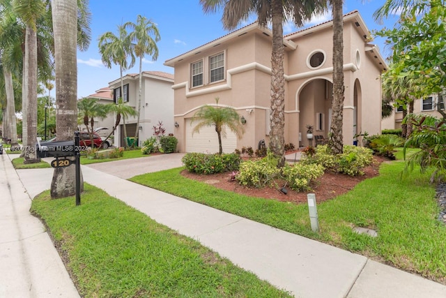 mediterranean / spanish-style home featuring a garage and a front yard