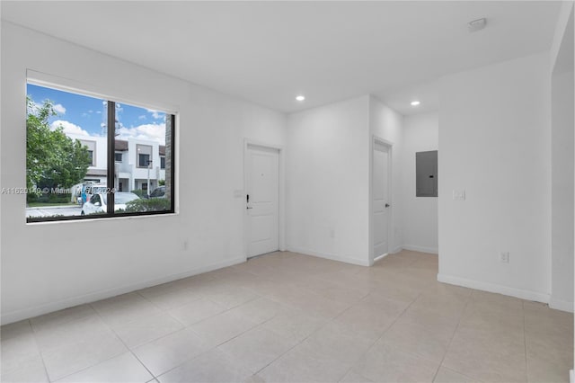 empty room featuring electric panel and light tile patterned floors