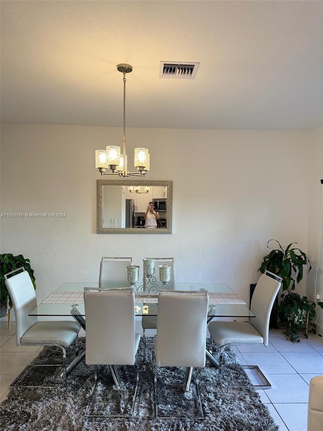 dining area featuring a notable chandelier and light tile patterned flooring