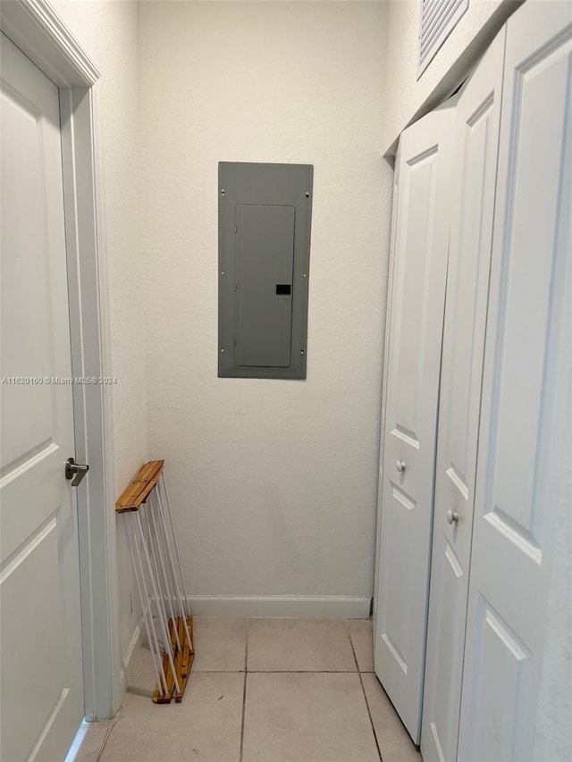 corridor with light tile patterned floors and electric panel