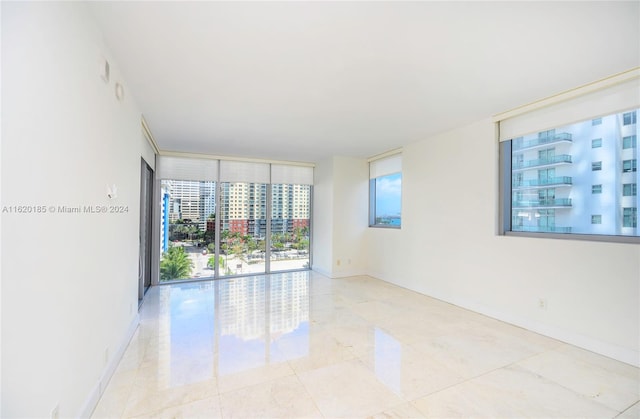 unfurnished room featuring light tile patterned flooring and expansive windows