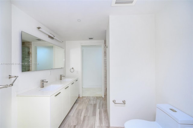 bathroom featuring toilet, hardwood / wood-style flooring, and double vanity