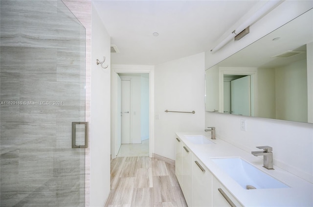 bathroom with double vanity and an enclosed shower