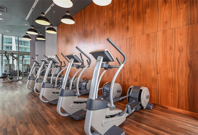 workout area with wood walls and hardwood / wood-style floors