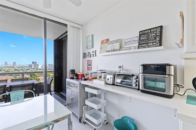 kitchen featuring expansive windows, ceiling fan, and tile patterned flooring