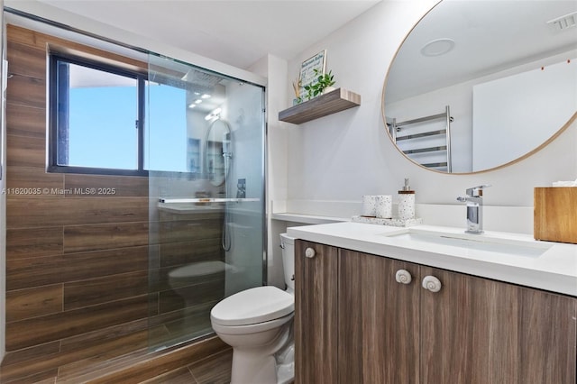 bathroom featuring vanity, radiator, an enclosed shower, and toilet