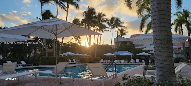 pool at dusk featuring a patio