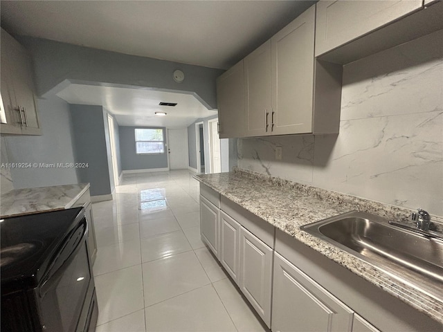 kitchen featuring backsplash, sink, gray cabinets, light tile patterned floors, and electric range oven