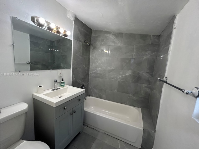 full bathroom featuring vanity, tiled shower / bath combo, and toilet