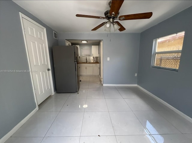 interior space with ceiling fan and light tile patterned flooring