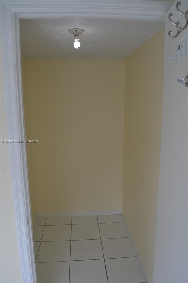 interior space featuring light tile patterned flooring and a textured ceiling