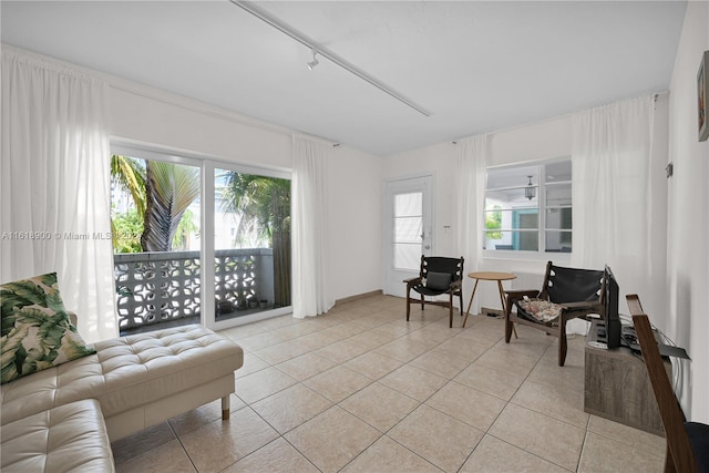 living area with light tile patterned floors and rail lighting