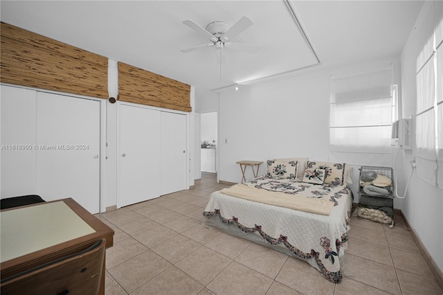 bedroom with ceiling fan, light tile patterned floors, and multiple windows