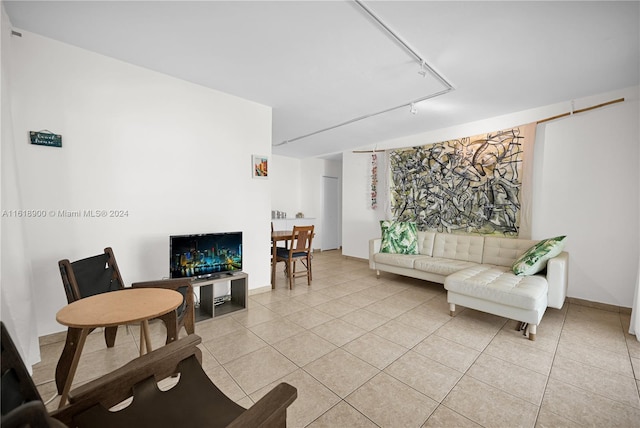 living room with rail lighting and light tile patterned flooring