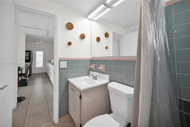 bathroom featuring vanity, tile patterned flooring, toilet, tile walls, and curtained shower