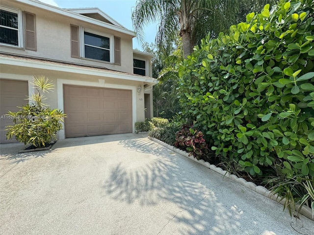 view of front of property with stucco siding, driveway, and a garage