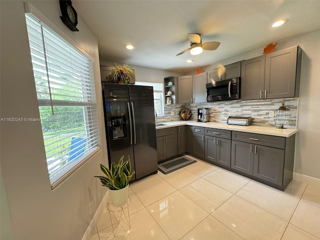 kitchen featuring black fridge with ice dispenser, gray cabinets, ceiling fan, backsplash, and light tile patterned flooring