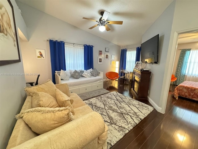 living room with ceiling fan, vaulted ceiling, a healthy amount of sunlight, and hardwood / wood-style flooring