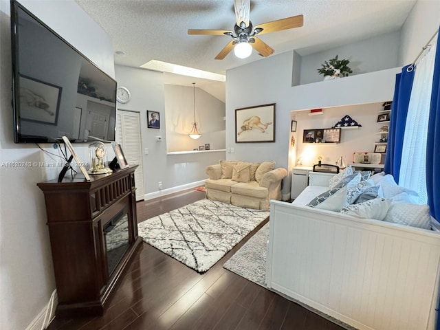 living room with ceiling fan, dark wood-type flooring, and a textured ceiling