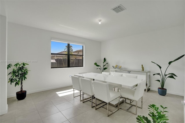 dining space featuring light tile patterned floors, visible vents, and baseboards