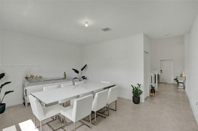 dining room featuring light tile patterned flooring, visible vents, and baseboards