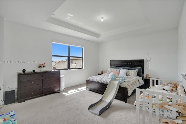 bedroom featuring carpet and a raised ceiling