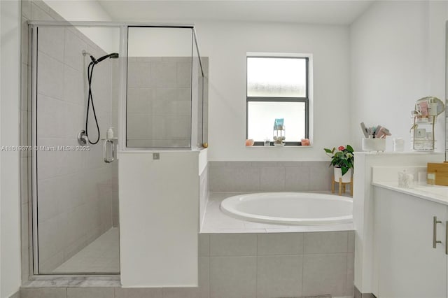 full bathroom with a stall shower, a garden tub, and vanity