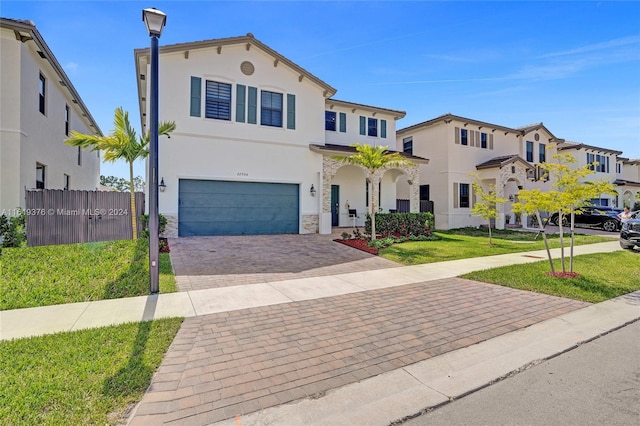 mediterranean / spanish home featuring a garage and a front lawn