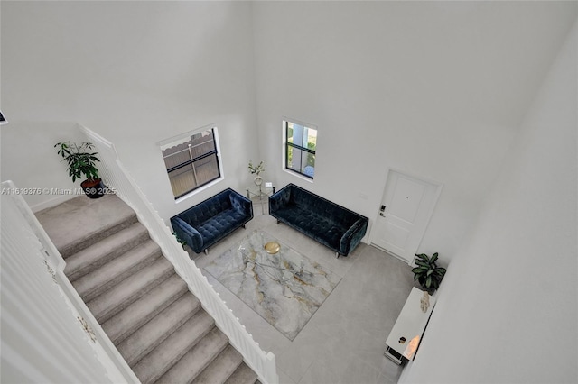 living room featuring a high ceiling and stairway