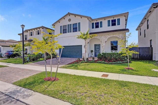 view of front of house featuring a garage, fence, decorative driveway, a front lawn, and stucco siding