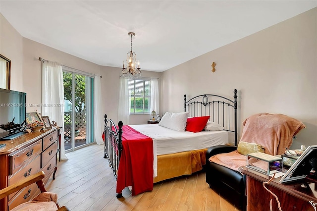 bedroom featuring access to exterior, light hardwood / wood-style floors, and an inviting chandelier