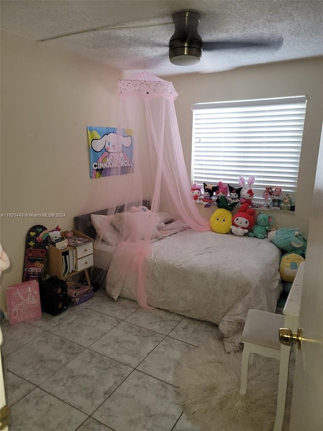 bedroom featuring tile patterned floors, a textured ceiling, and ceiling fan