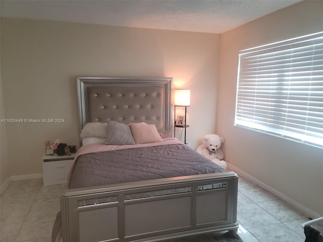 bedroom featuring a textured ceiling and light tile patterned floors