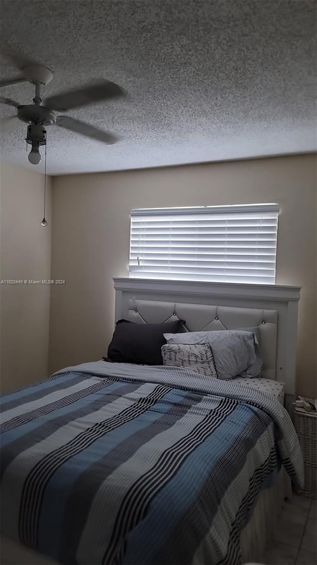 bedroom with a textured ceiling and ceiling fan