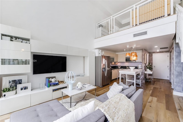 living room featuring light hardwood / wood-style flooring and a high ceiling