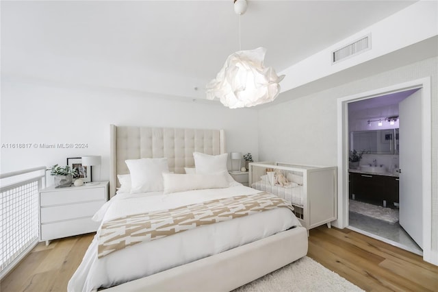 bedroom with sink and light hardwood / wood-style floors