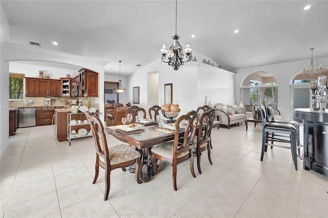 dining room with a chandelier, vaulted ceiling, and light tile patterned flooring