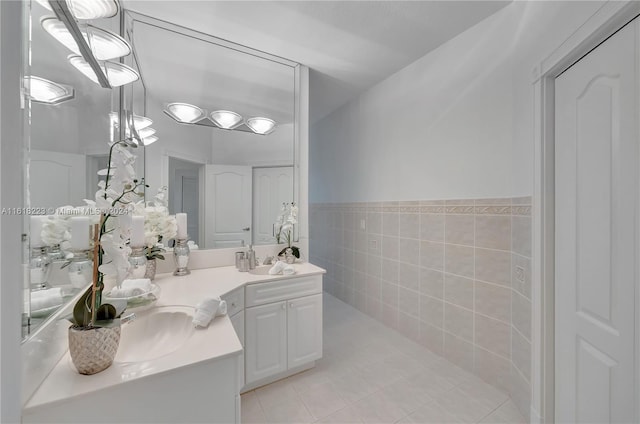 bathroom with tile patterned floors, vanity, and tile walls