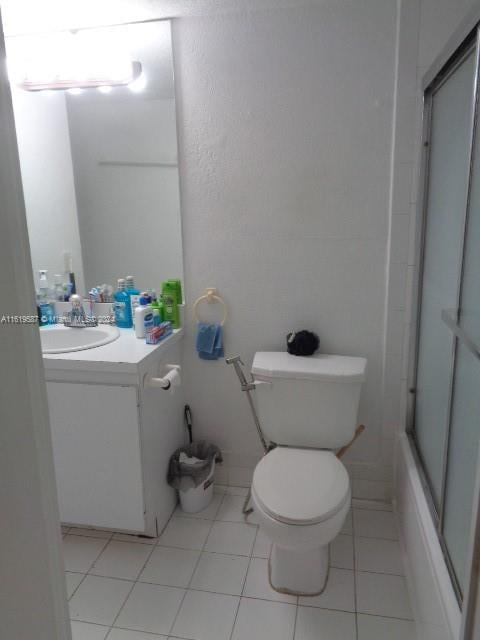 full bathroom with vanity, tile patterned floors, enclosed tub / shower combo, and toilet