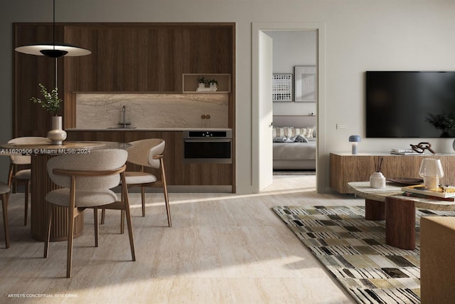 interior space featuring oven, sink, light wood-type flooring, and decorative light fixtures