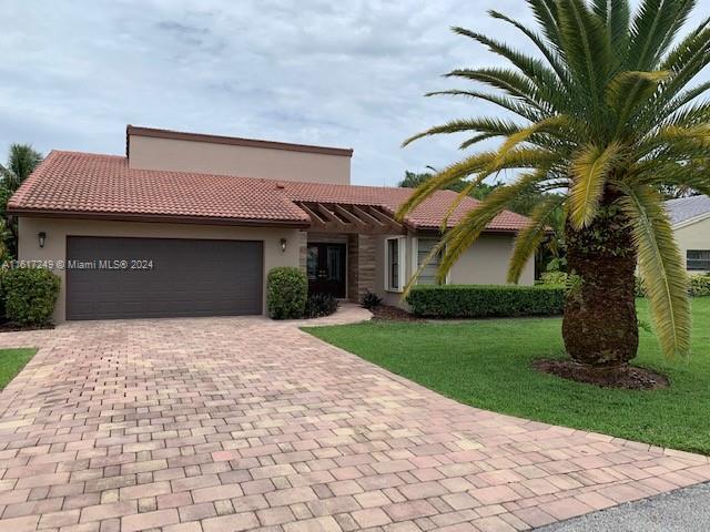 mediterranean / spanish-style house featuring a front yard and a garage