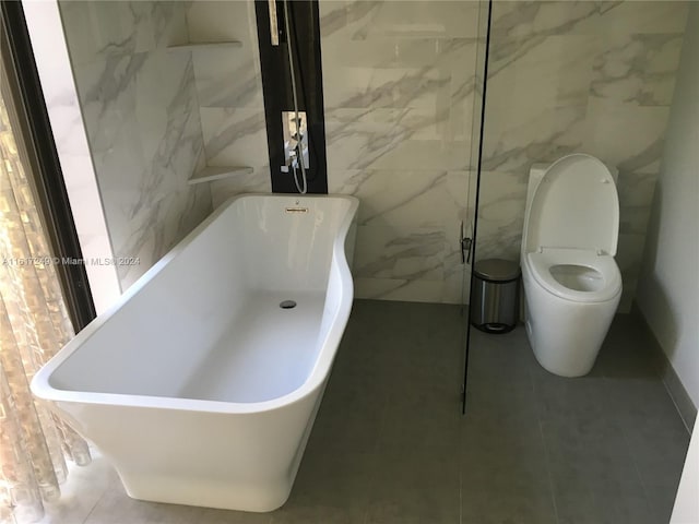 bathroom featuring tile patterned flooring, a bath, and toilet