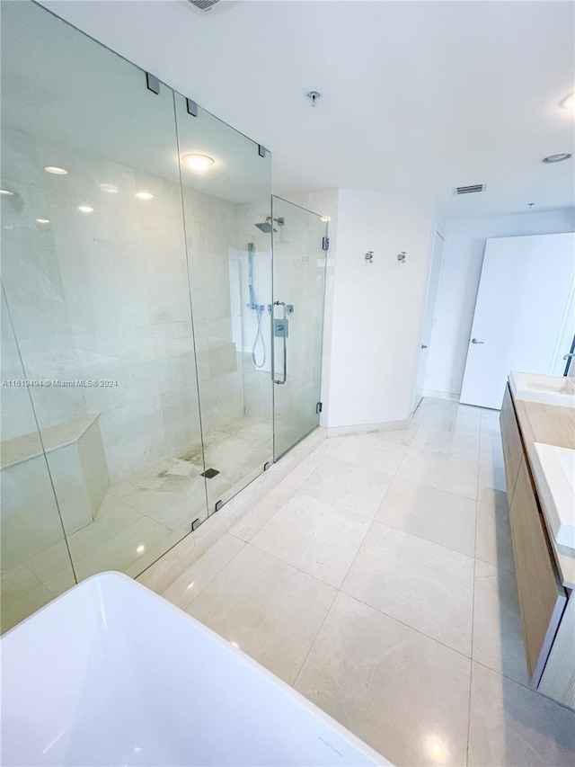 bathroom featuring visible vents, vanity, a freestanding bath, baseboards, and a shower stall