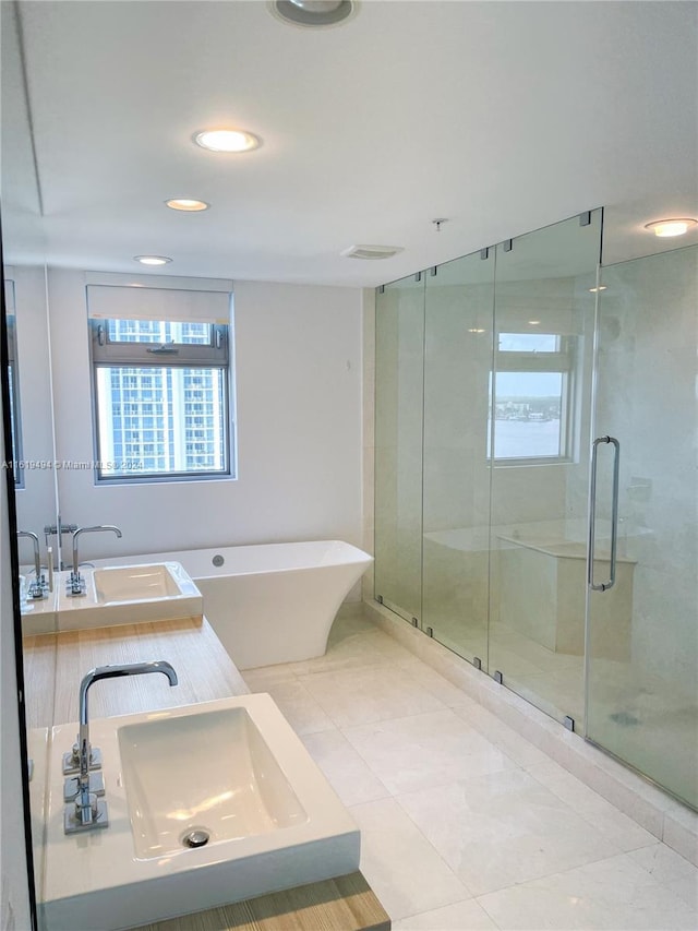 full bath featuring a soaking tub, a sink, and a shower stall