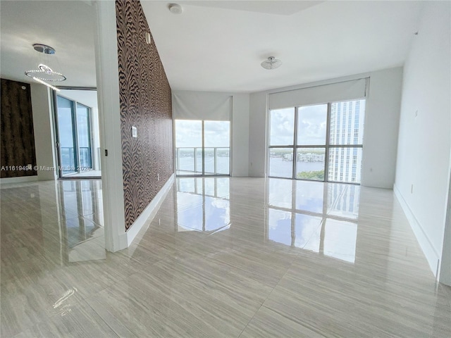 spare room with a water view and baseboards