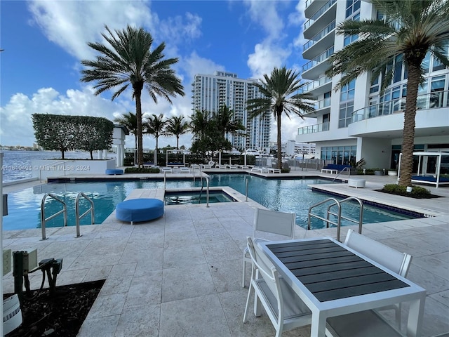 community pool with a water view and a patio