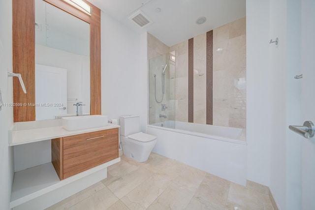 full bathroom featuring tile patterned flooring, toilet, tiled shower / bath combo, and vanity